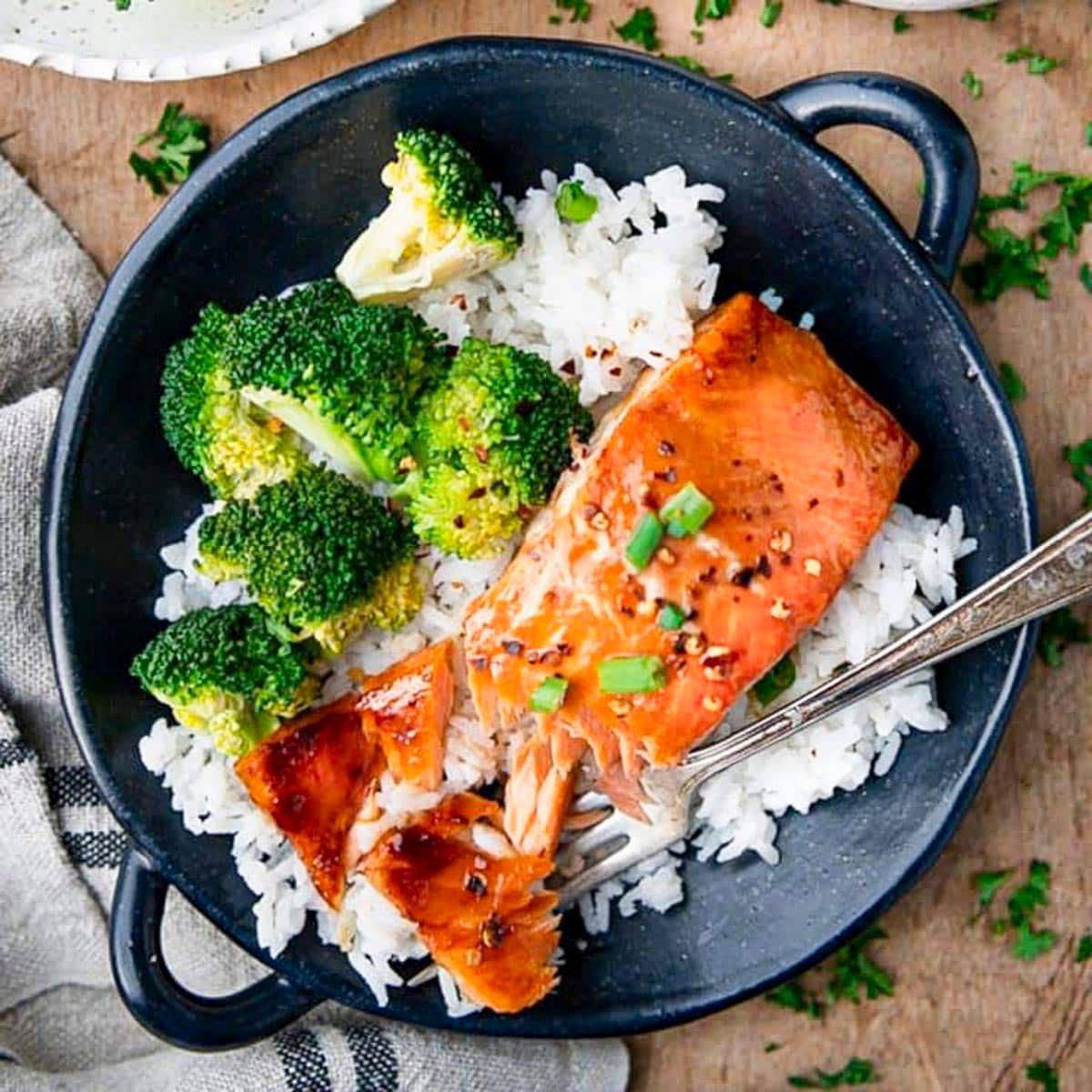 overhead shot of grilled honey glazed salmon with various herbs and spices around it