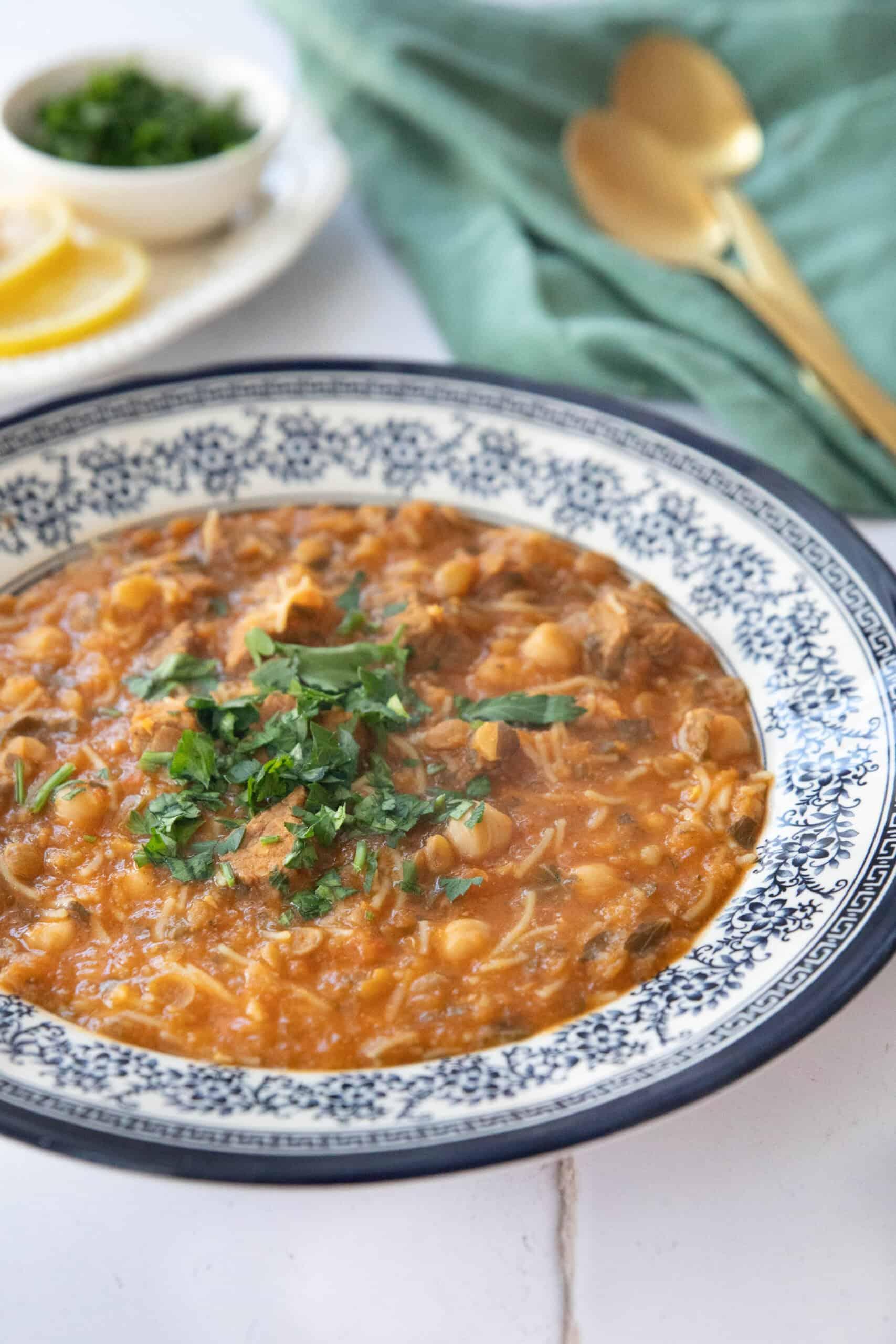 Close up shot of a bowl of lentil soup with crispy chickpeas, garnished with fresh parsley