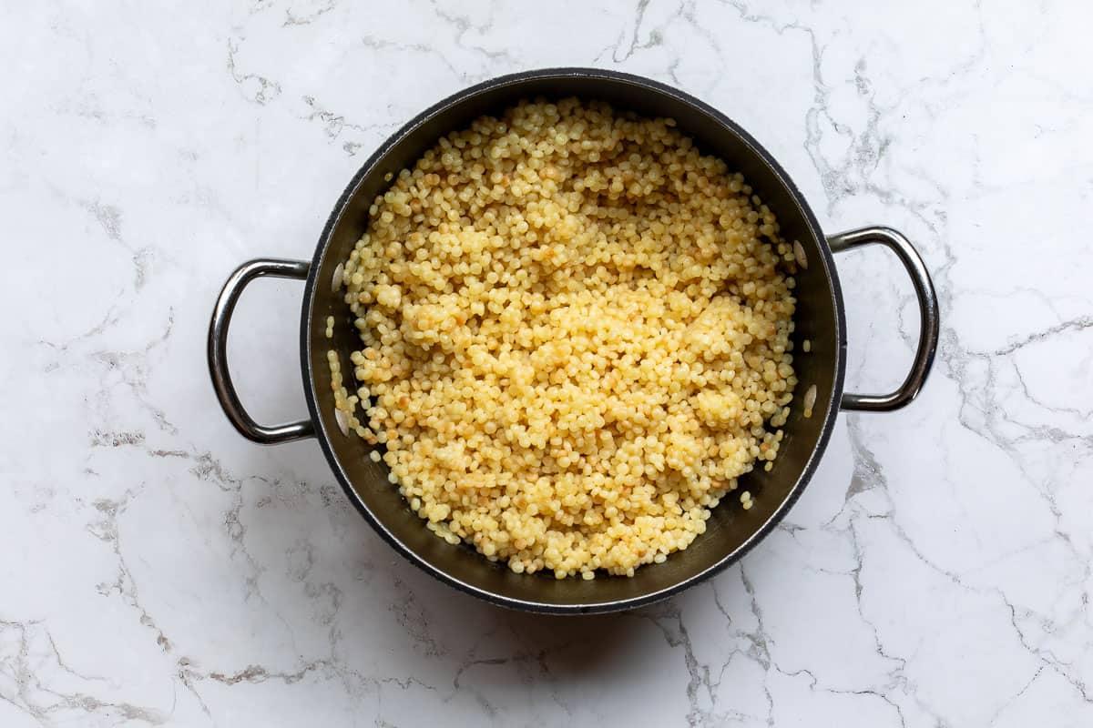 pearl couscous being cooked in a saucepan