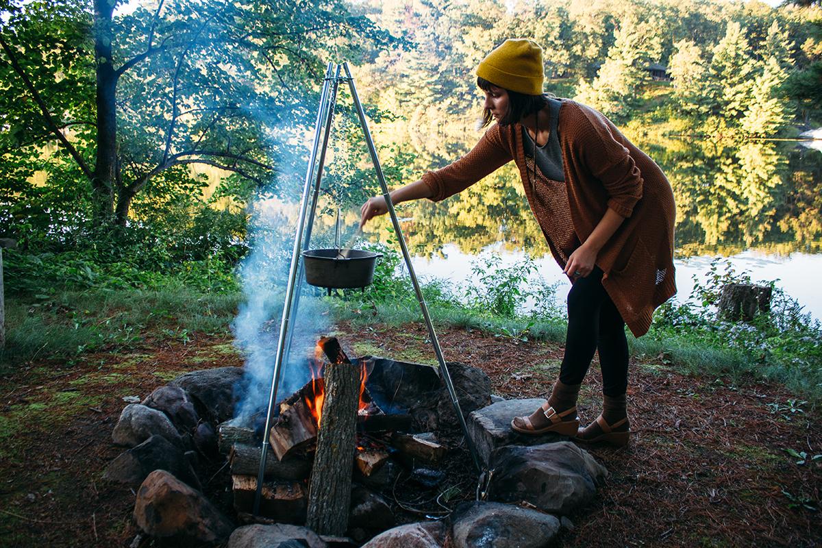 Smiling person enjoying a bowl of campfire chili outdoors