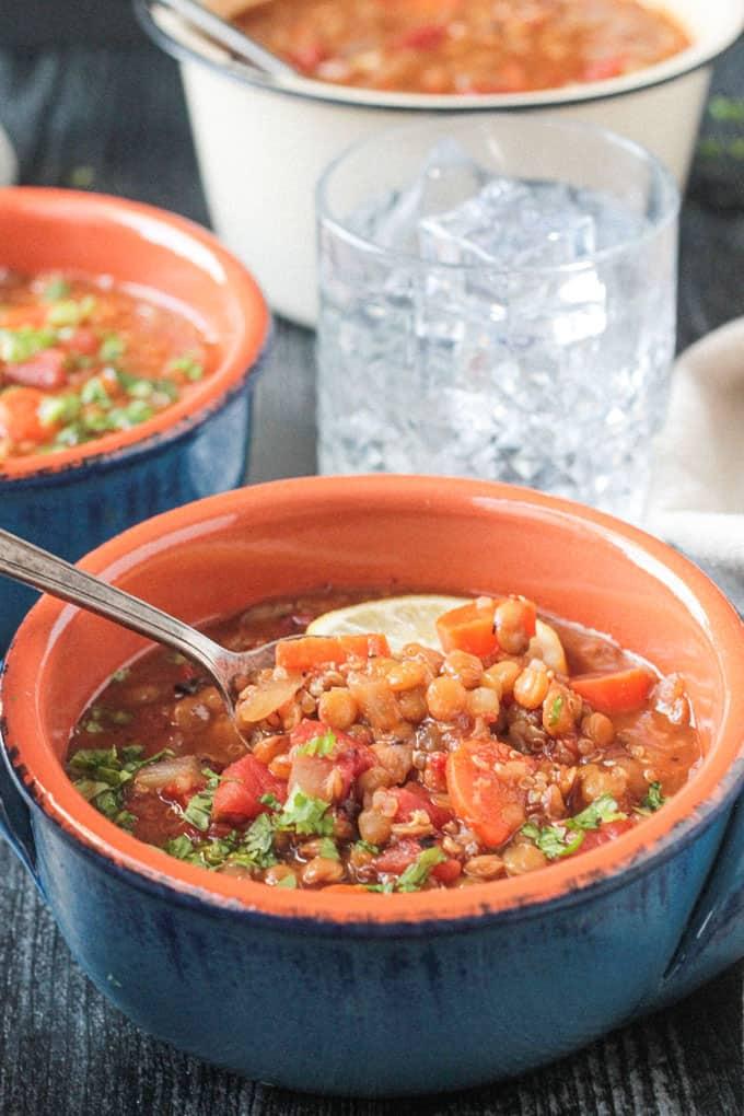 close-up of a spoonful of lentil soup being lifted from a bowl