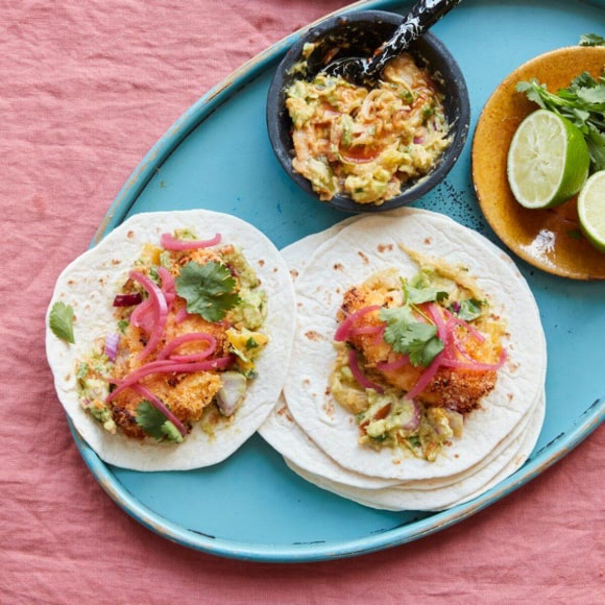 A person enjoying kimchi fish tacos outside
