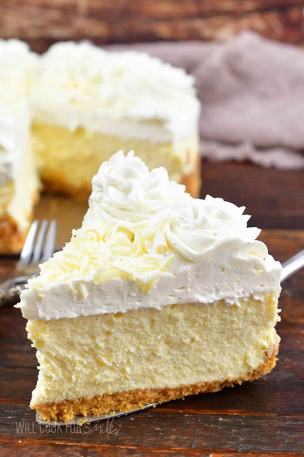 person gently slicing a creamy vanilla bean cheesecake