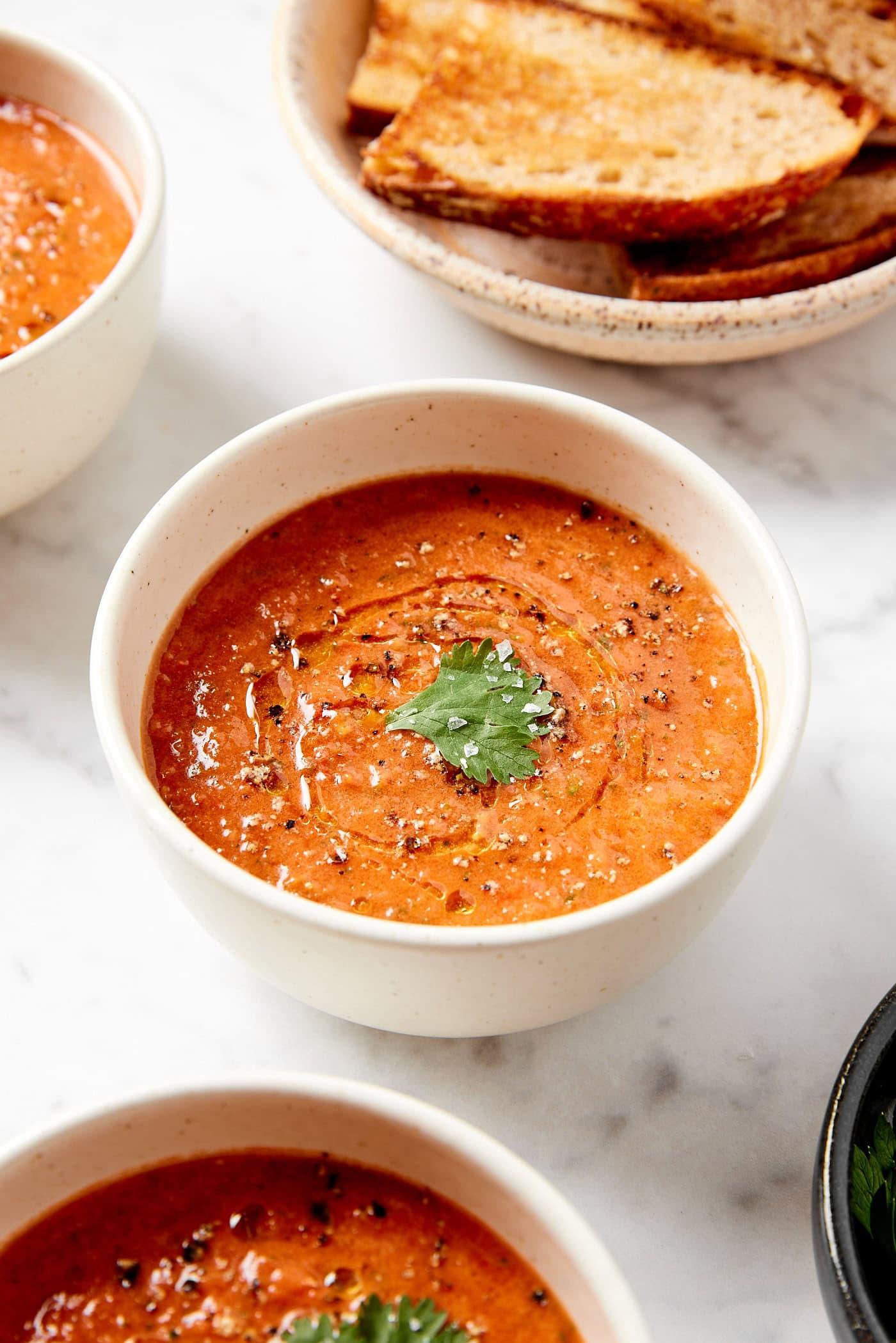 Close-up shot of a bowl of gazpacho with rice, garnished with fresh herbs