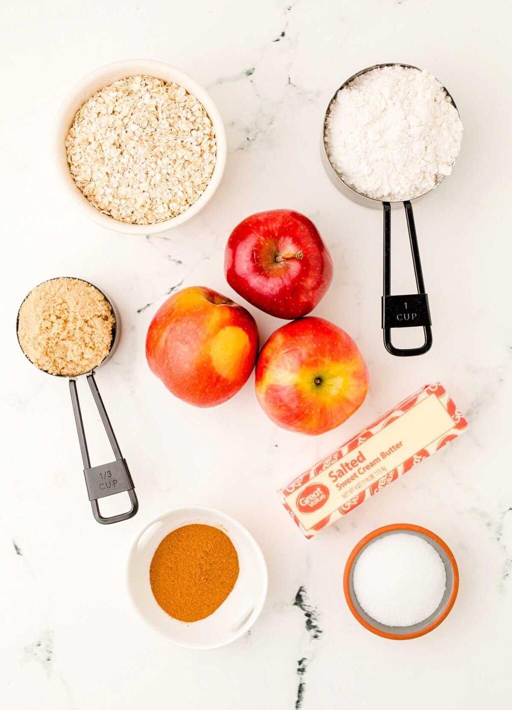 ingredients laid out on a wooden table, ready to make apple crisp