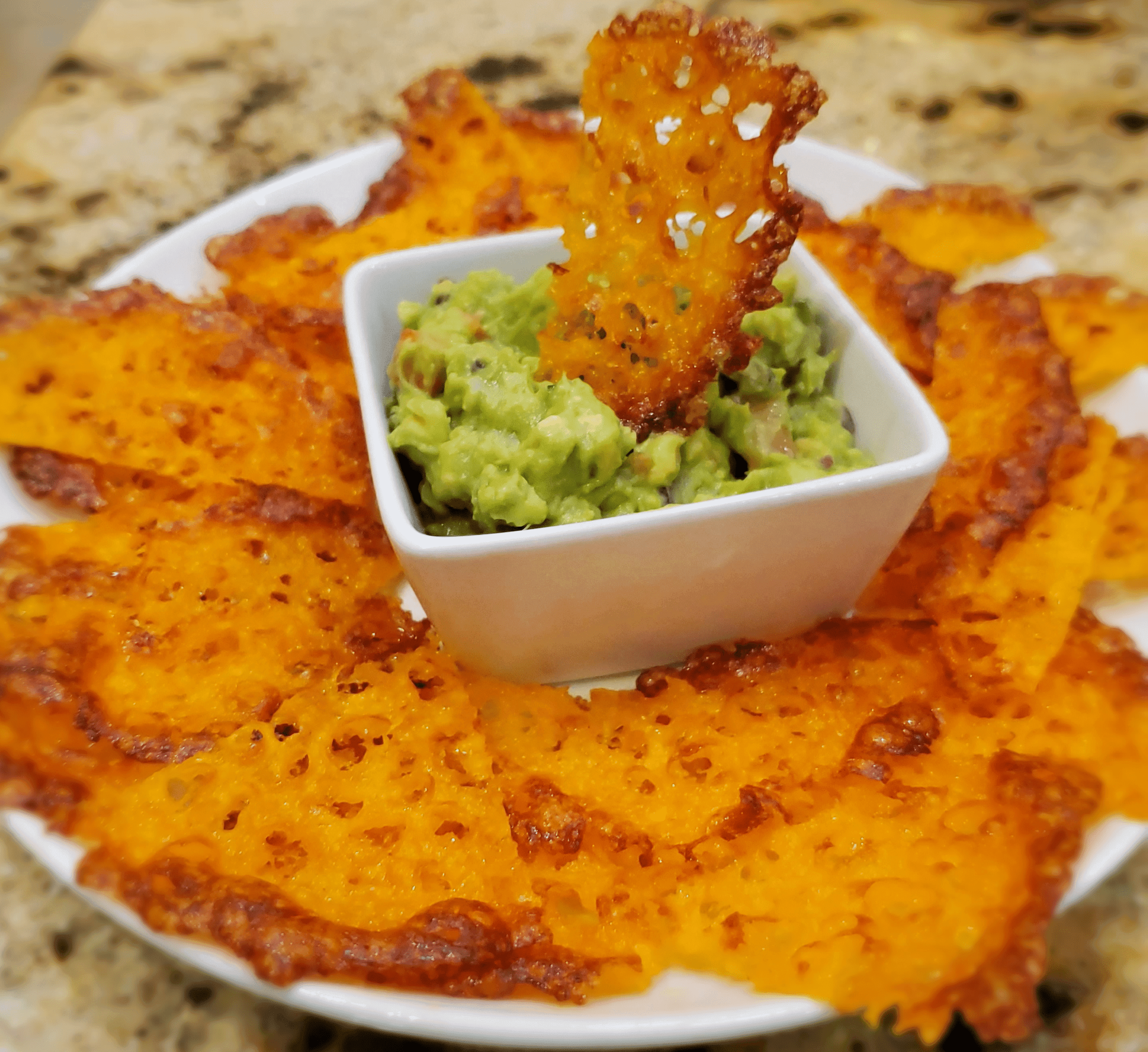 Wheat Keto Cheese Crackers being dipped in guacamole