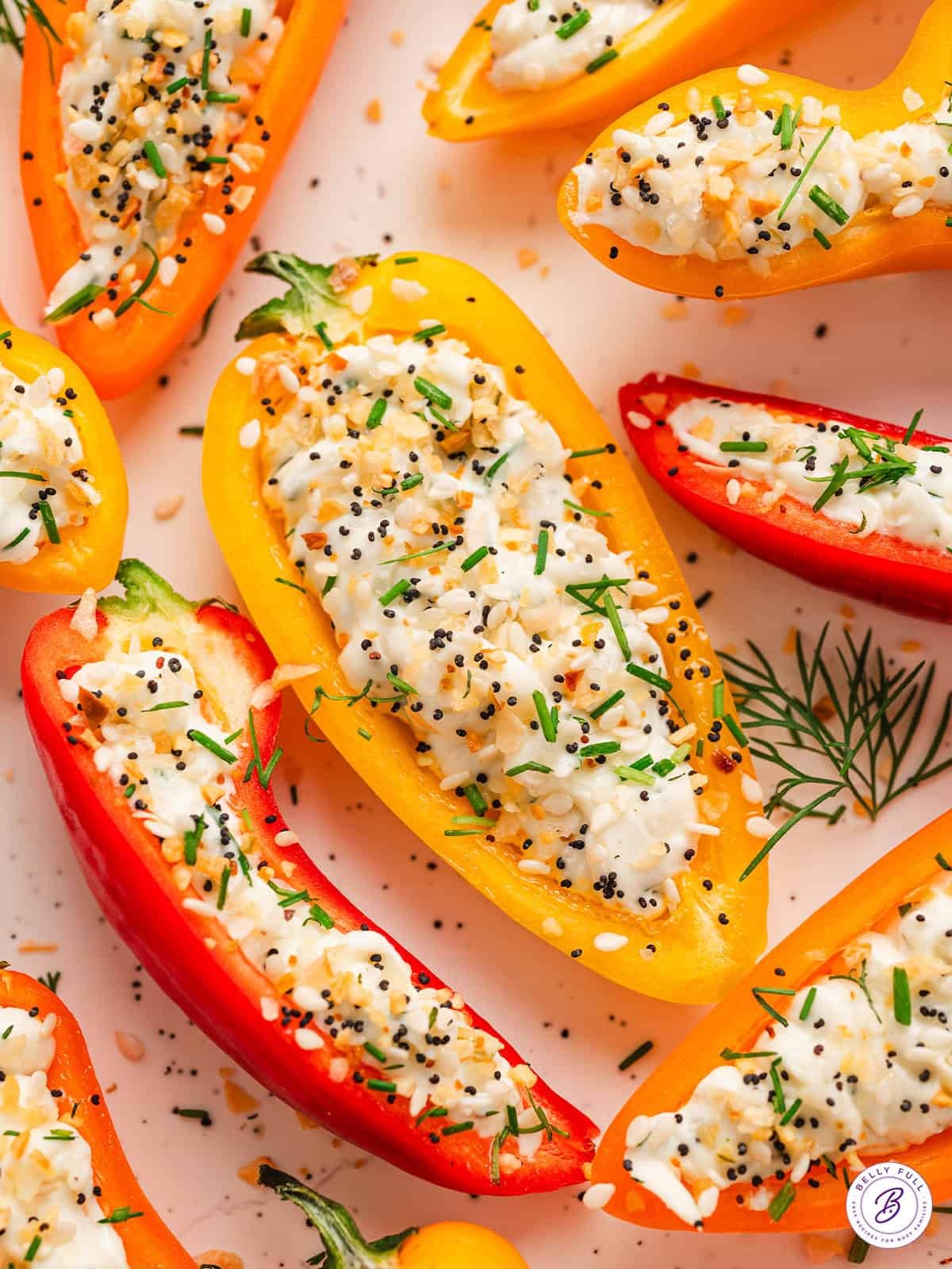Close-up shot of colorful bell peppers stuffed with vibrant pink gravlax and garnished with fresh dill