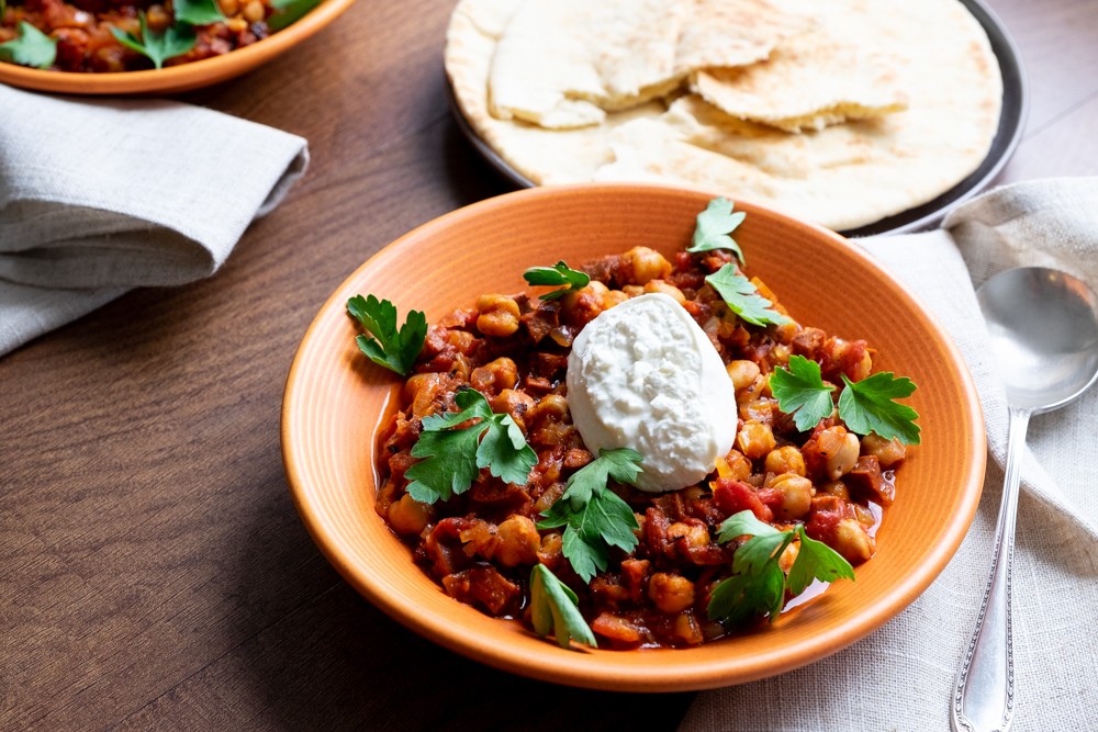 Slow cooker filled with spicy chorizo and chickpea chili topped with lime crema