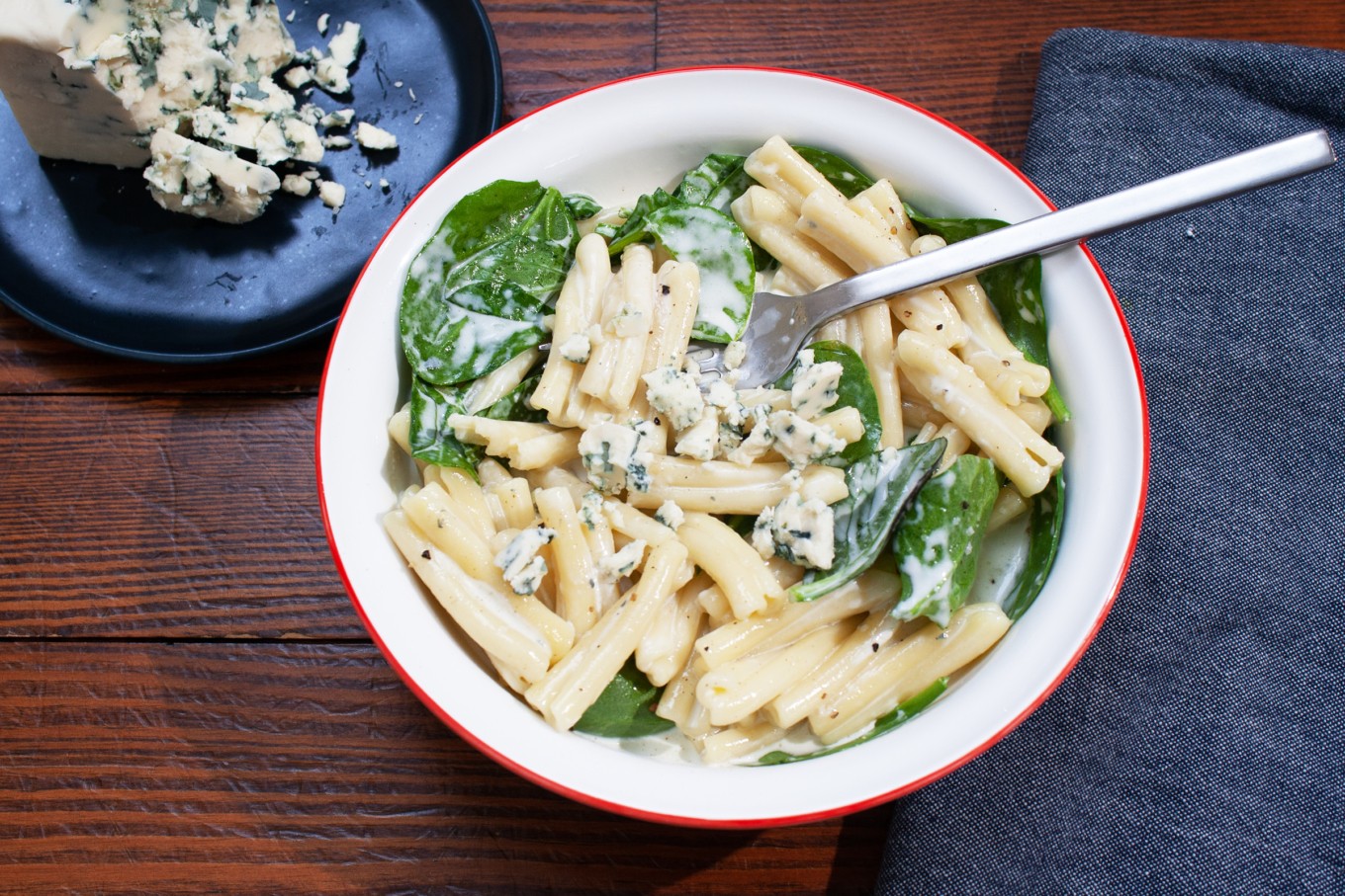 Creamy spinach and gorgonzola pasta in a bowl, garnished with fresh parsley