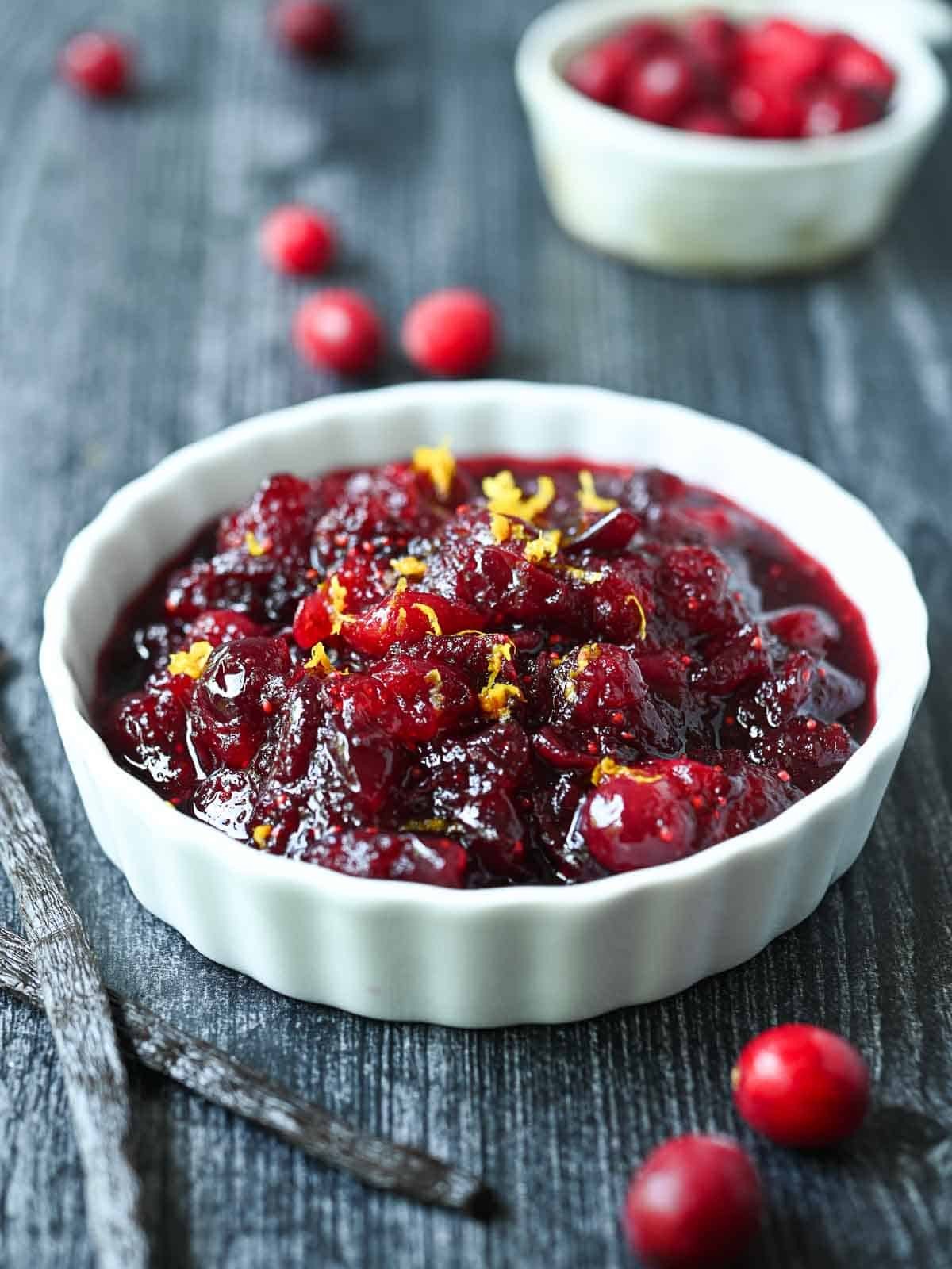 Homemade cranberry sauce with vanilla bean and fresh cranberries in a rustic bowl