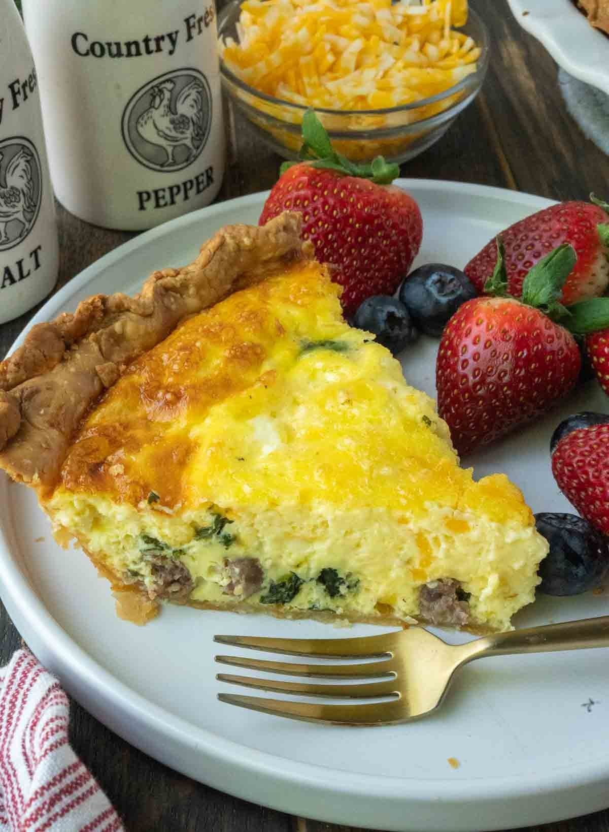 Slice of sausage and spinach quiche on a plate