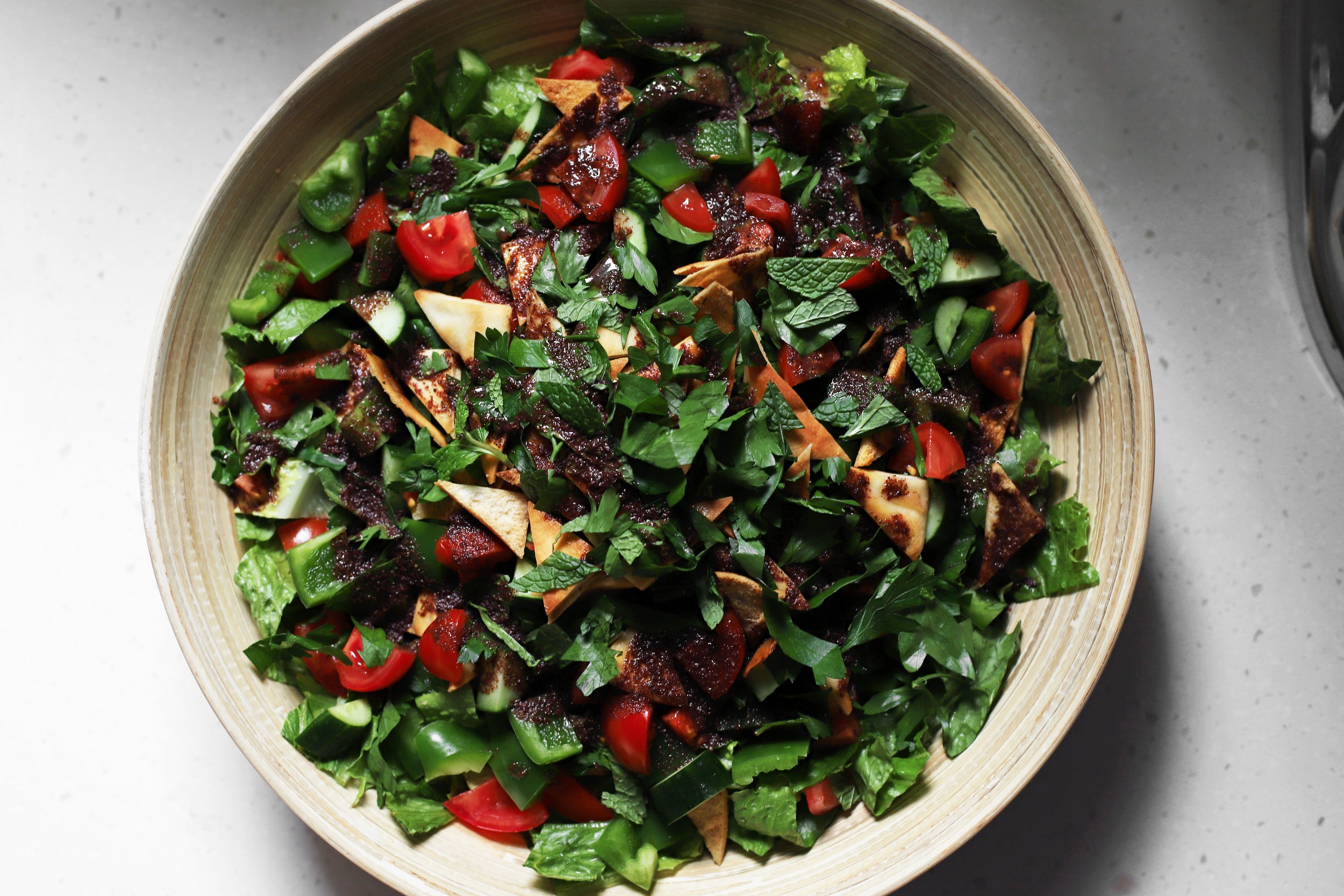 coffee cardamom fattoush salad on a rustic wooden table