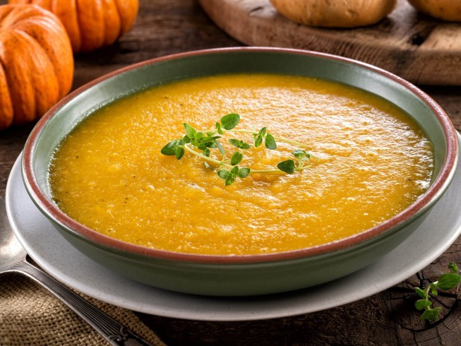 Close-up shot of creamy pumpkin and sausage stew in a slow cooker