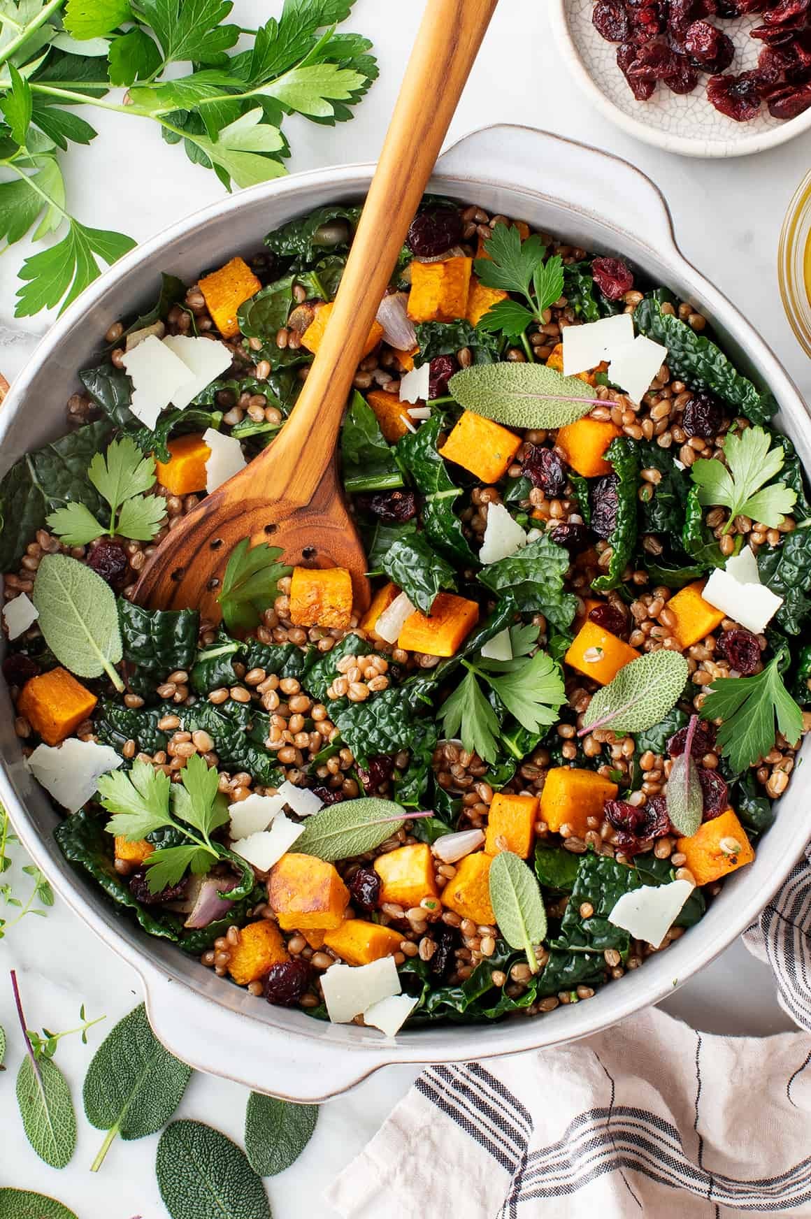 A vibrant wheat berry salad with fresh herbs and vegetables in a rustic bowl