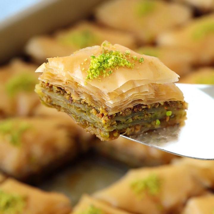 golden brown baklava with pistachios and syrup drizzle