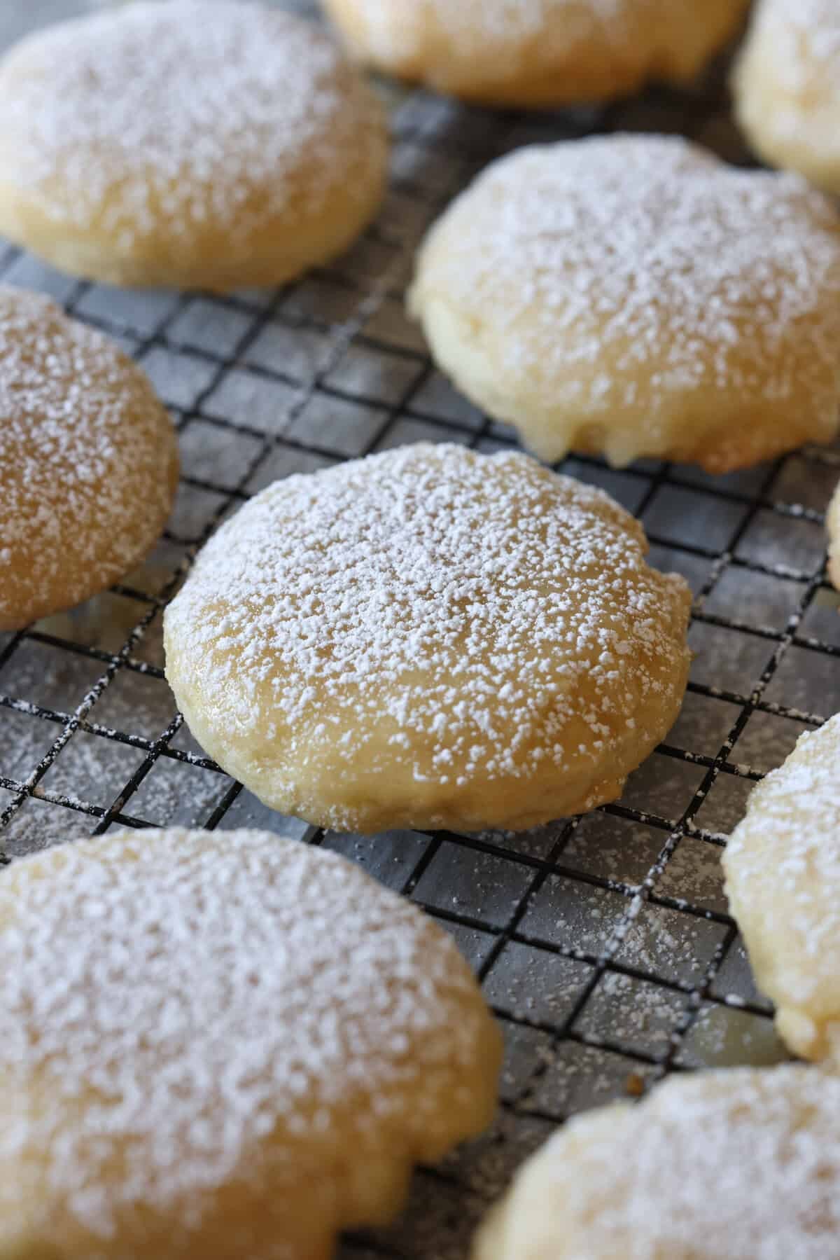 close up of soft, perfectly baked sugar cookies on a cooling rack, some with simple glaze