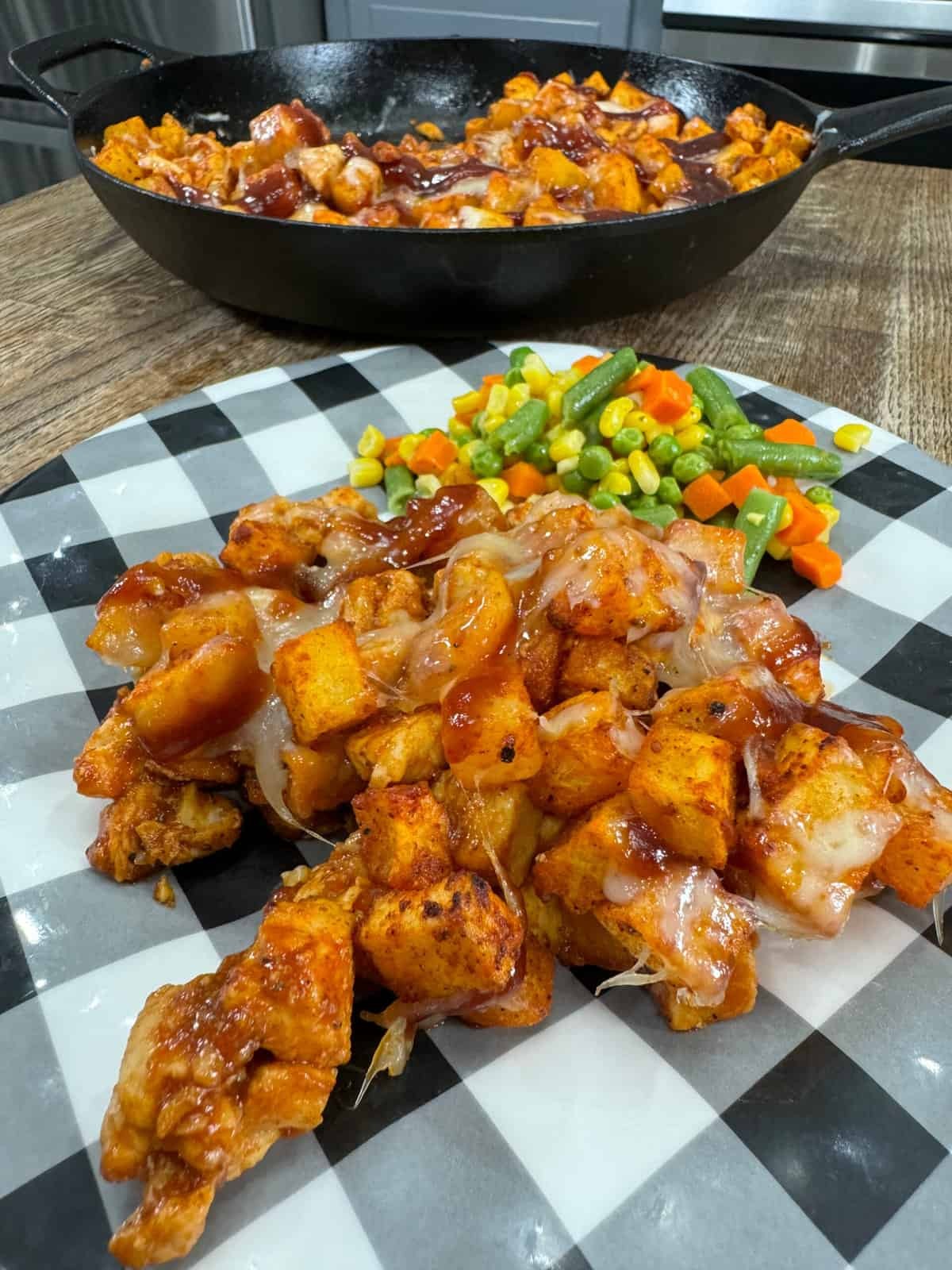Boiled potatoes tossed in BBQ sauce next to grilled BBQ chicken