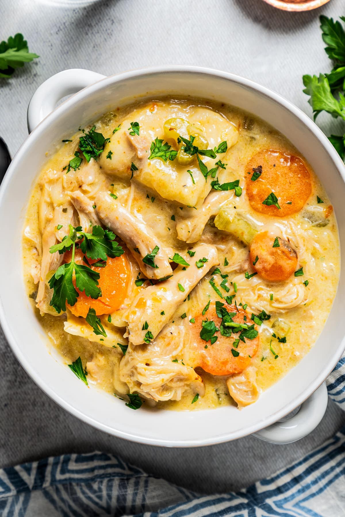 A steaming bowl of Instant Pot Chicken and Dumpling Soup with Thyme, garnished with fresh parsley.