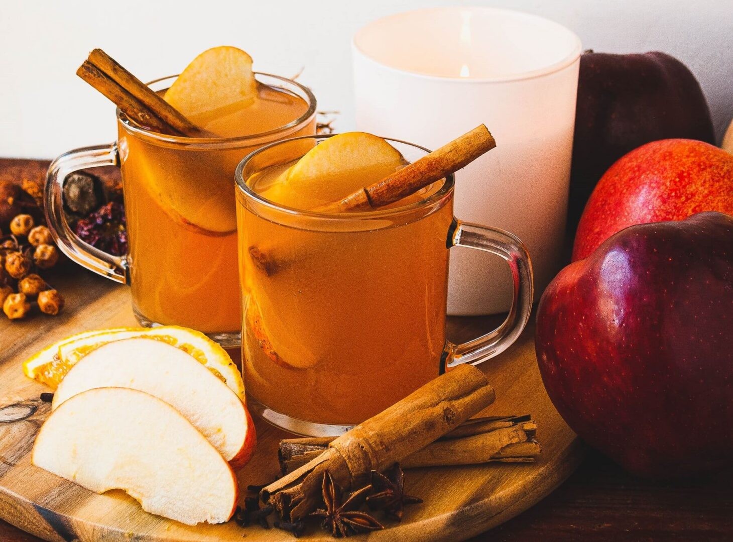 steaming mug of gingerbread apple cider garnished with cinnamon sticks