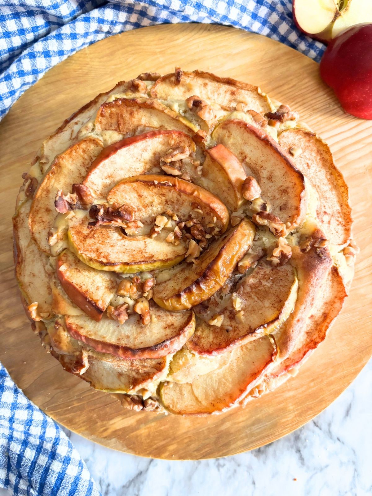 cinnamon apple cake with a slice cut out, served on a rustic wooden board