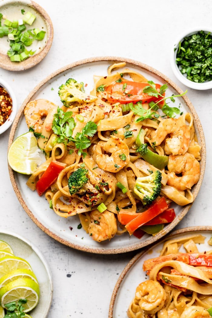 Close-up shot of a vibrant shrimp stir-fry with rice noodles and a rich peanut sauce