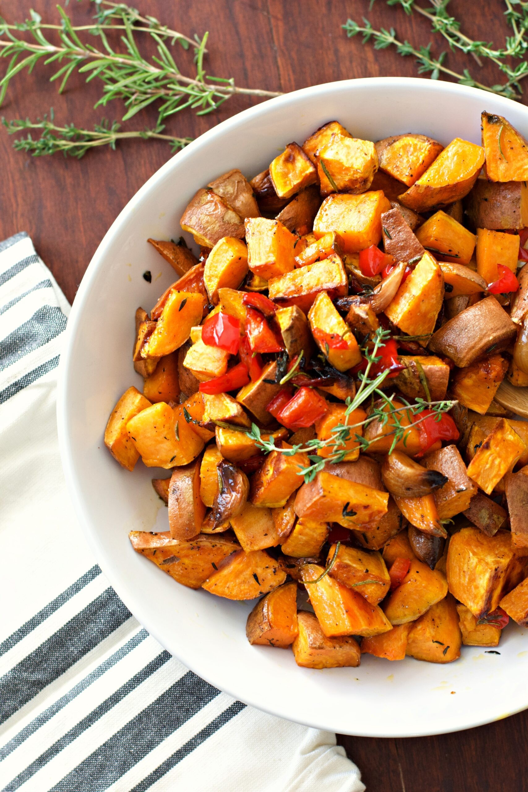 Paprika-roasted sweet potatoes with pecan crumble, garnished with fresh herbs