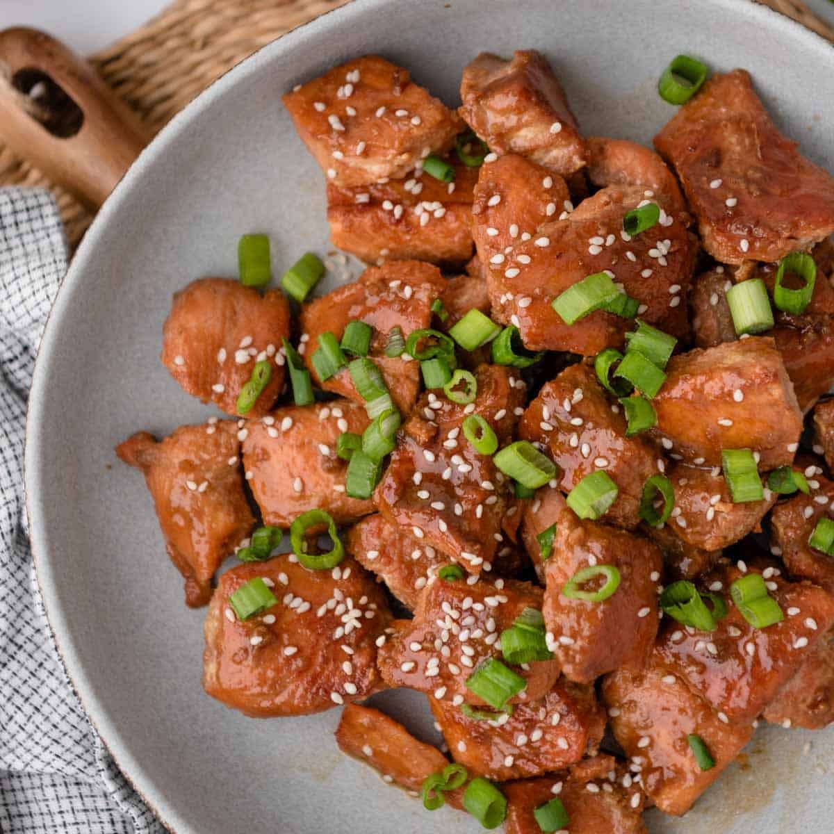 Close-up shot of a single-serving of Simple One-Pot Teriyaki Salmon in an oven-safe skillet, garnished with sesame seeds and green onions