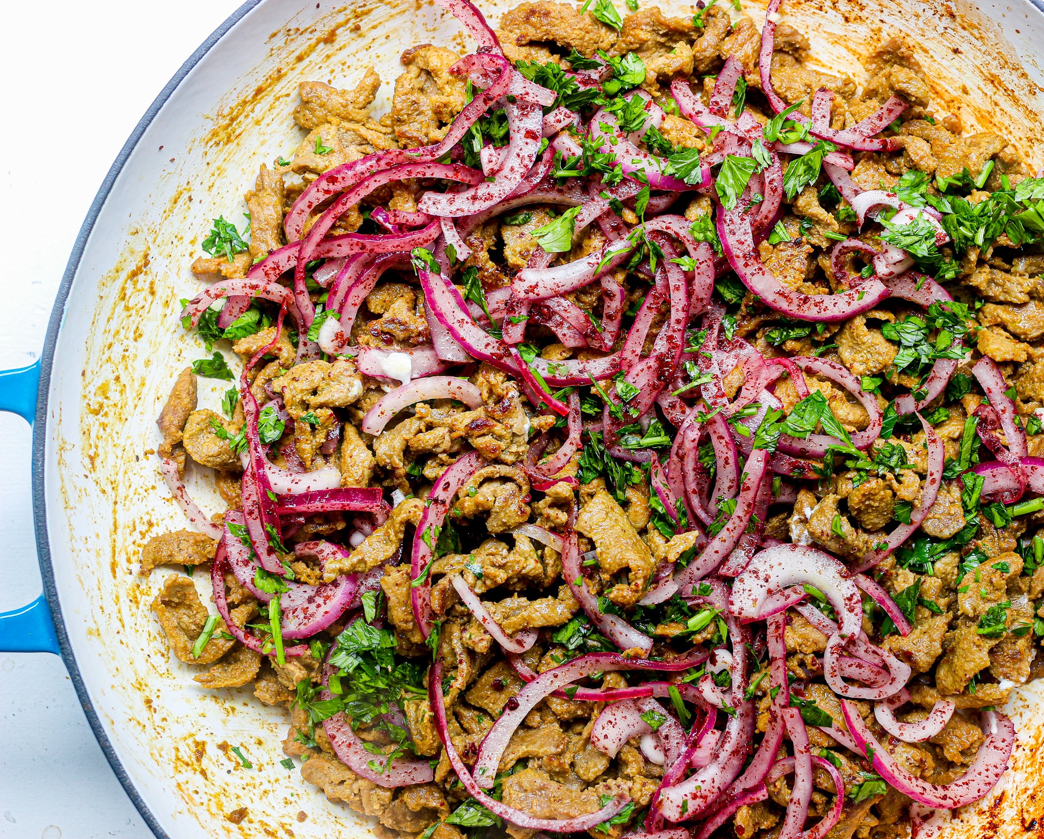 Close-up shot of delicious lamb shawarma with za'atar and olive tapenade, garnished with fresh herbs and served on a platter.
