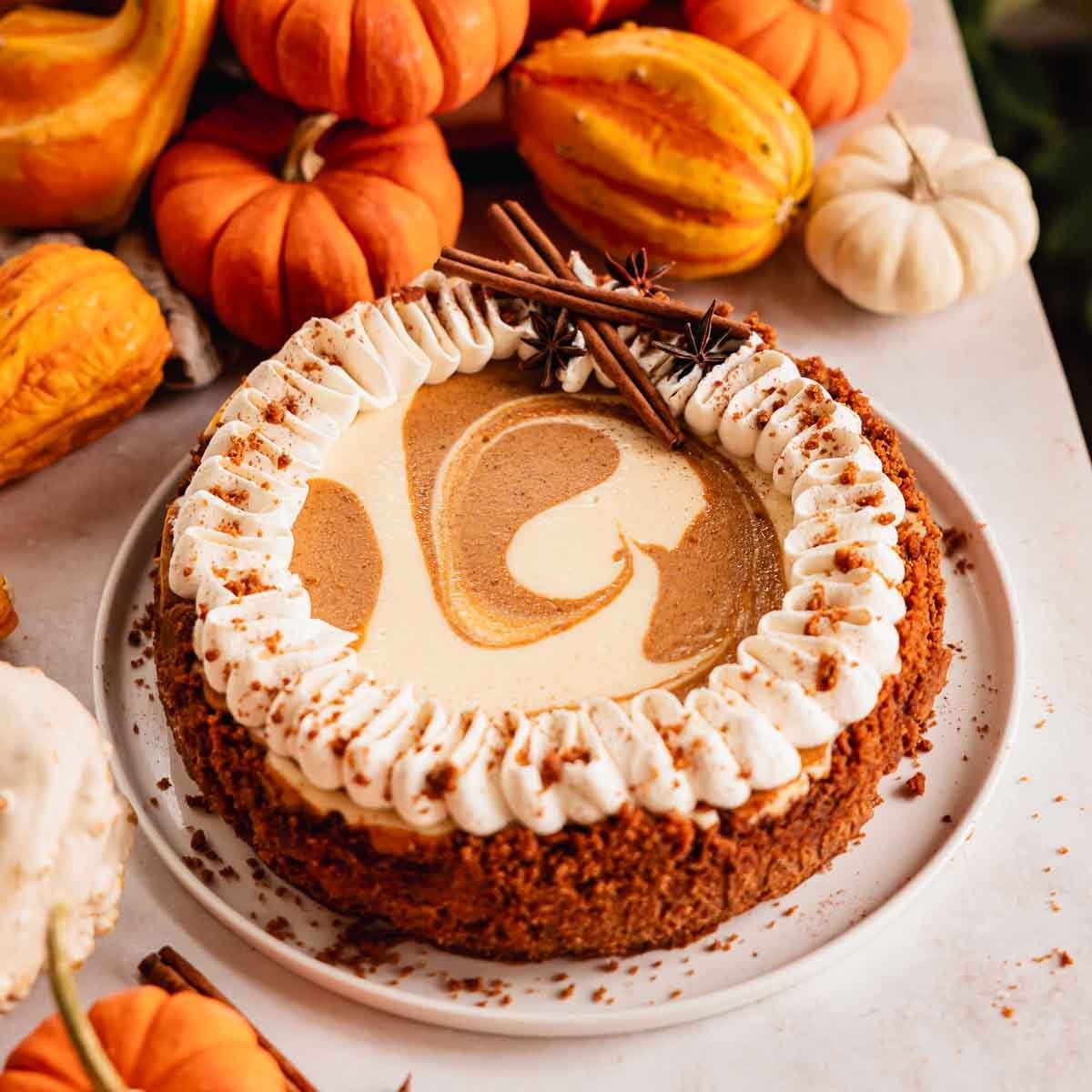 Delicious pumpkin cheesecake with creamy swirl on a rustic table, autumn decor