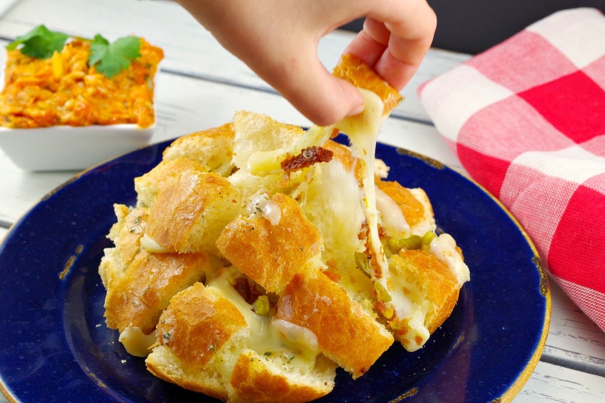 cheesy pull-apart garlic bread bites on a serving platter, happy people sharing food