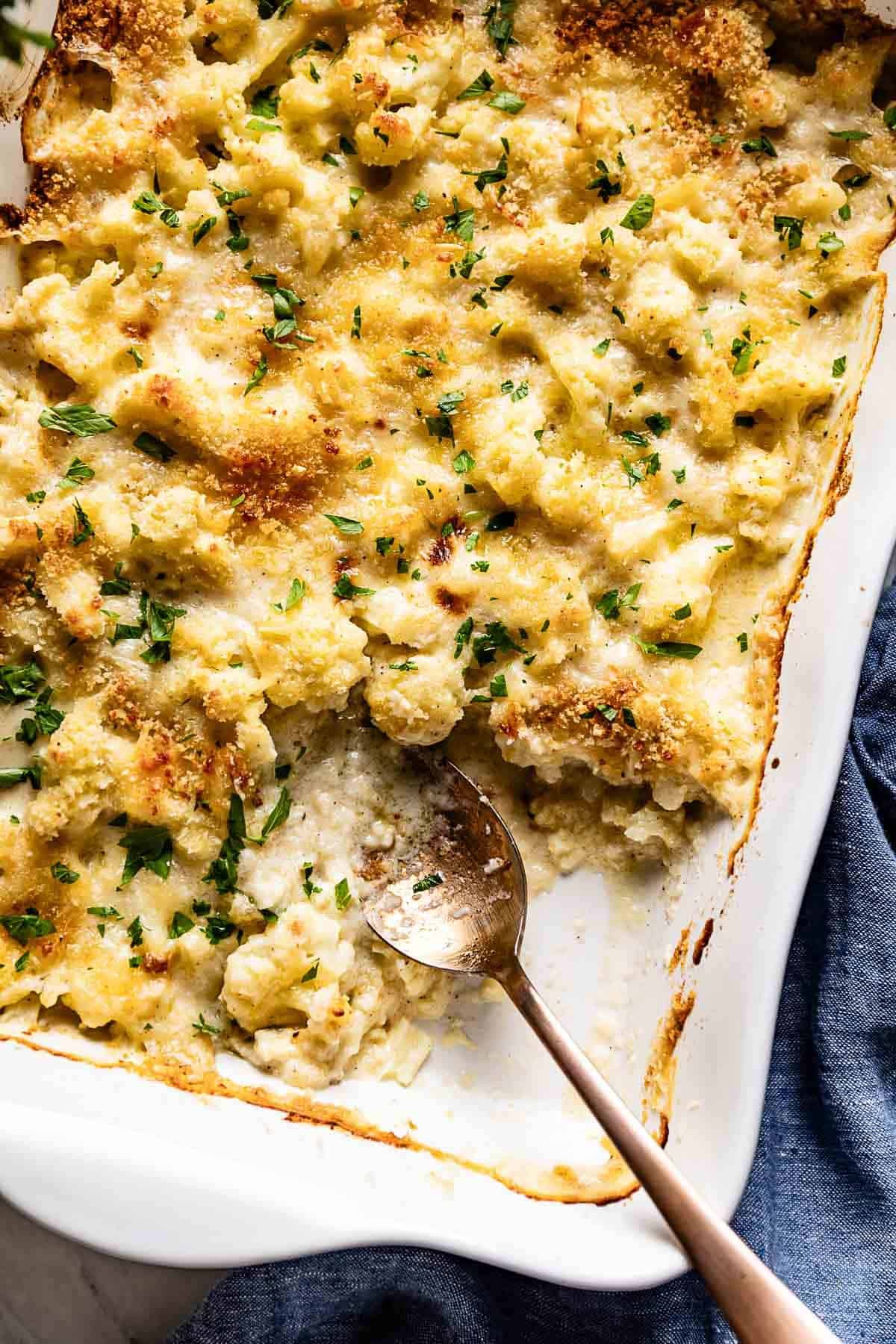 A golden-brown gratin of squash and cauliflower, bubbling cheese on top.