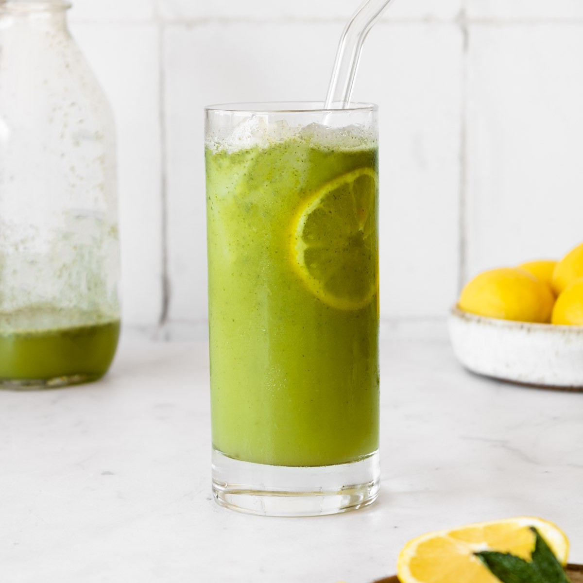 Refreshing glass of green apple mint lemonade with ice and mint sprigs