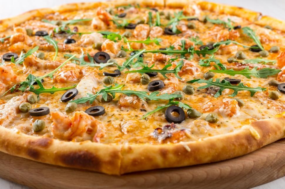 A delicious homemade pizza with melted cheese and various toppings on a rustic wooden table