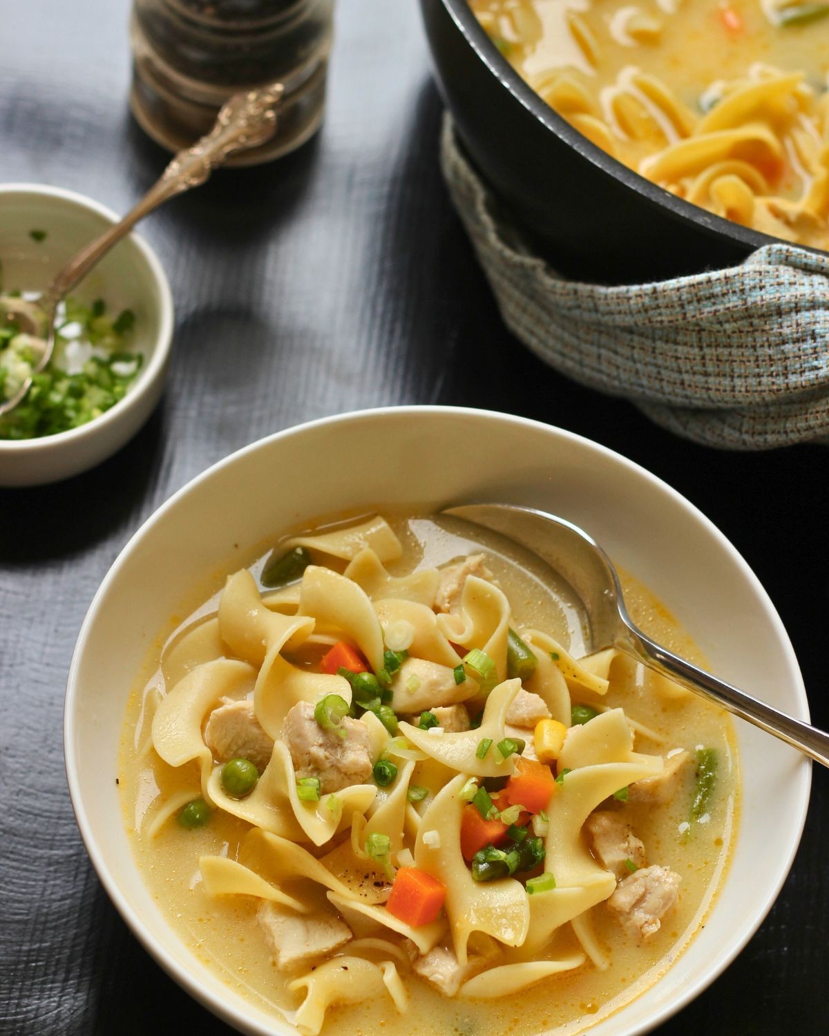 bowl of creamy chicken noodle soup with a spoon