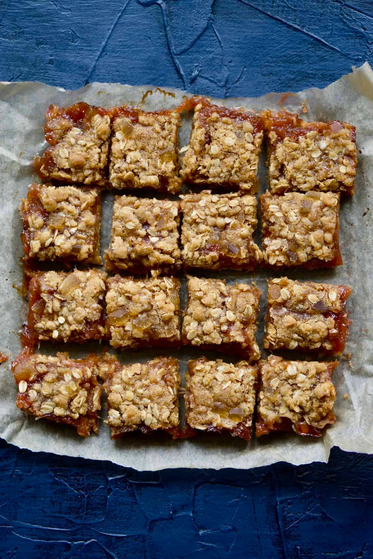 rhubarb ginger crumble bars on a rustic wooden surface