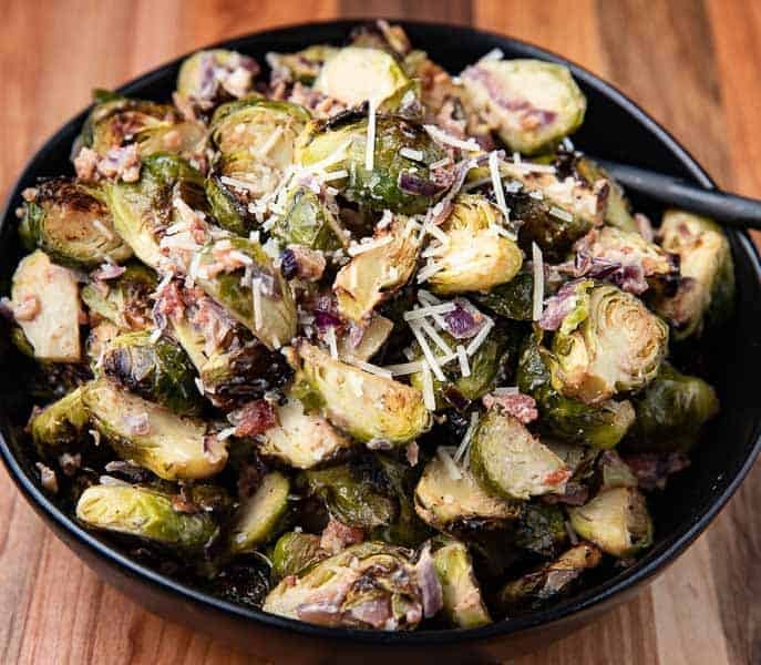 Close-up shot of roasted Brussels sprouts with balsamic glaze, garnished with parmesan cheese