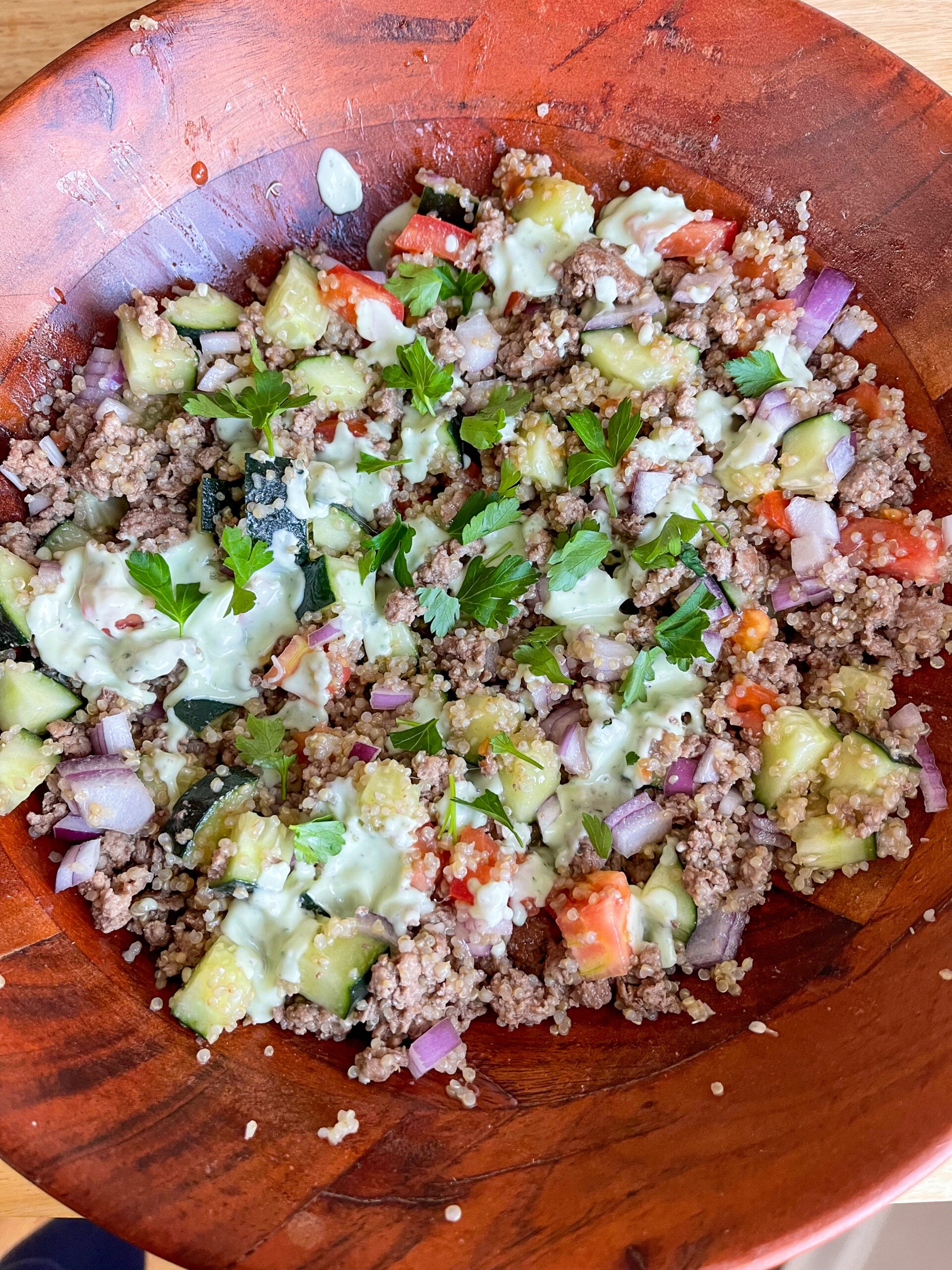 a vibrant bowl of coconut yogurt and quinoa salad with colorful vegetables and herbs