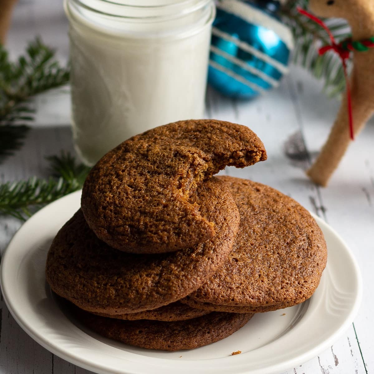 plate of soft chewy molasses cookies with dark sweet flavor, rustic kitchen background