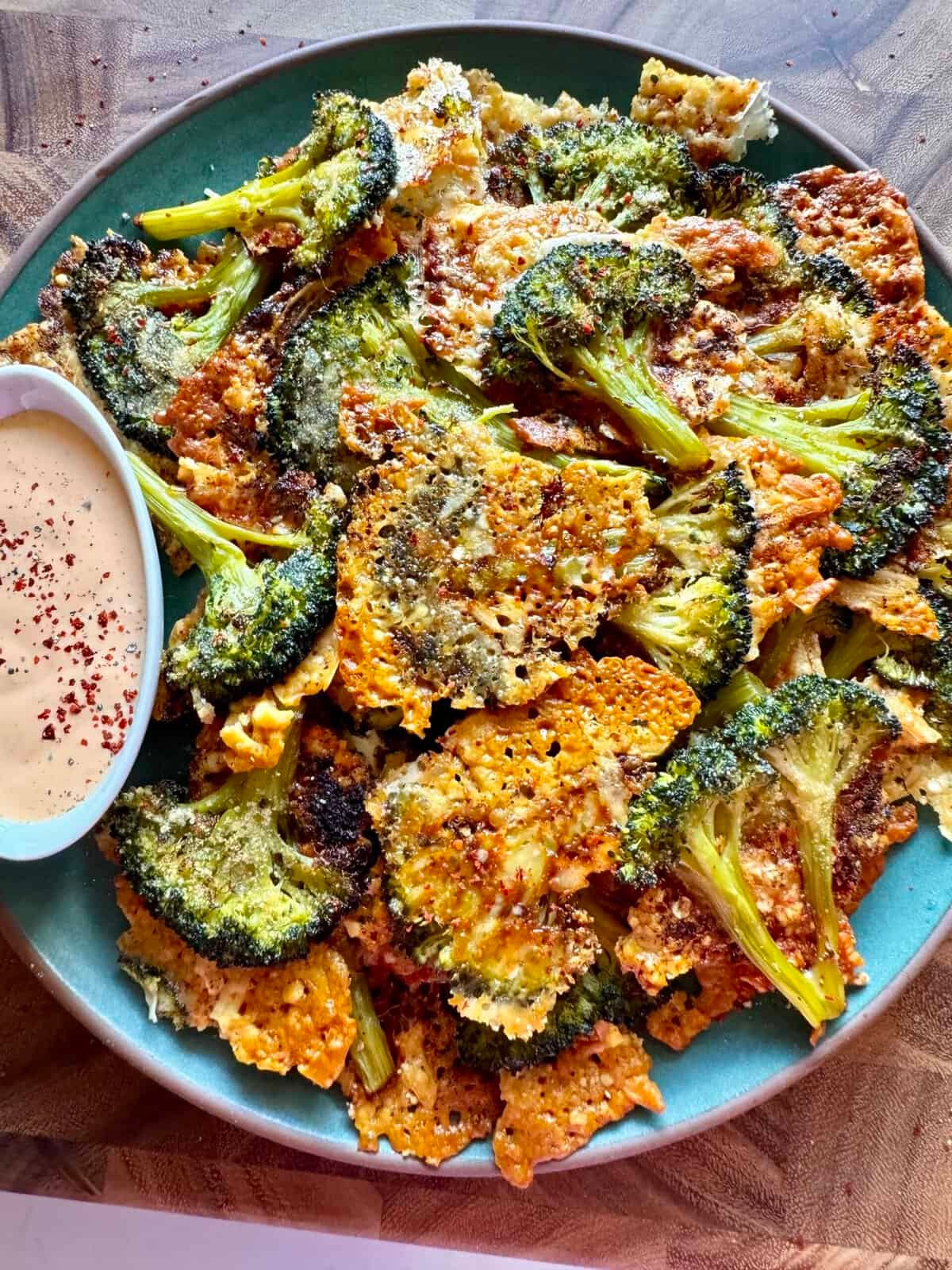 crispy cheddar cheese broccoli stem chips on a wooden board
