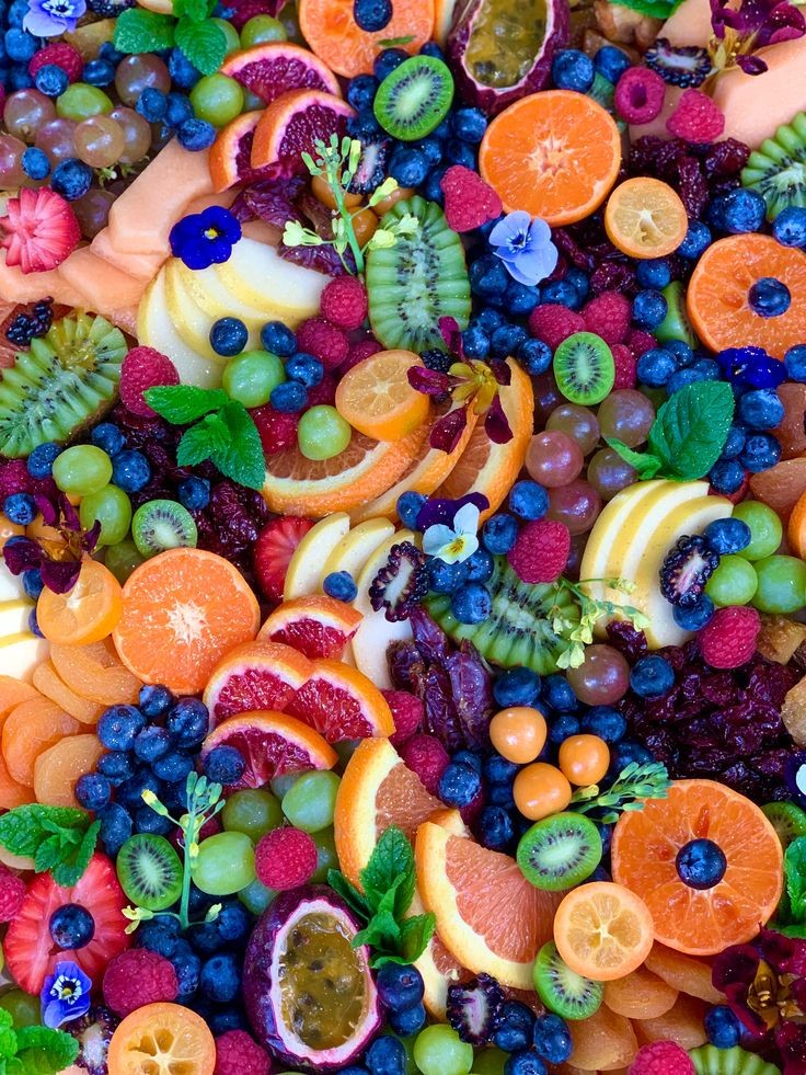 A vibrant and colorful fruit platter featuring glistening cherries arranged artistically alongside other seasonal fruits