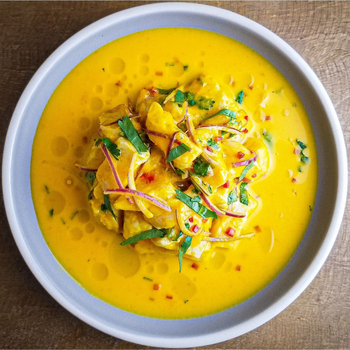 Close-up shot of vibrant ceviche with aji amarillo marinade, garnished with cilantro and red onion