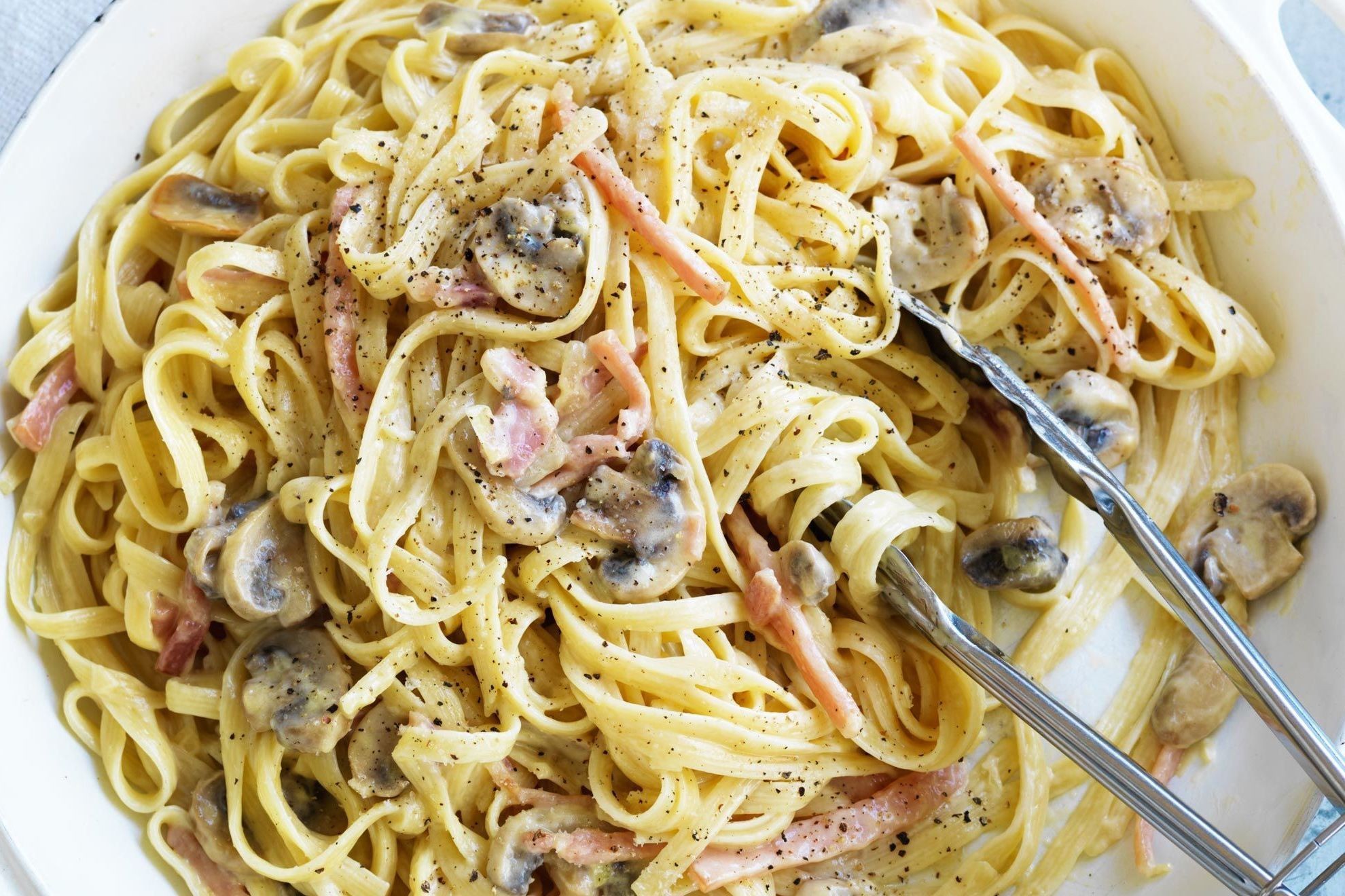 A bowl of creamy carbonara pasta with crispy bacon