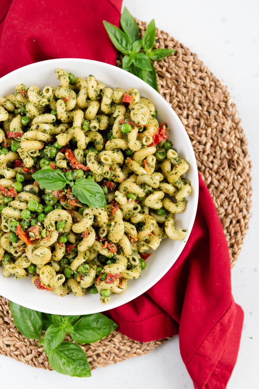 A vibrant pasta salad with pesto, sun-dried tomatoes, and fresh basil