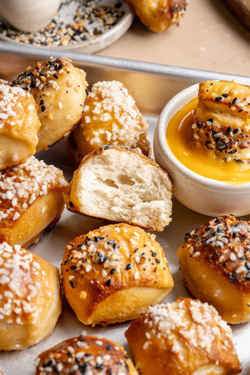 freshly baked golden brown salt dough pretzel bites on a baking sheet, close up, warm lighting