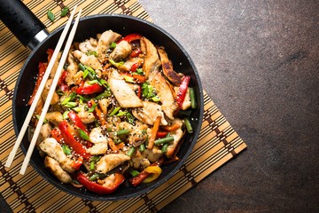 vibrant vegetable stir-fry with carrots, chicken, and tofu in a wok