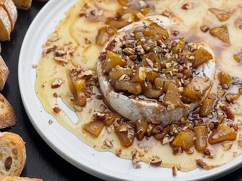 Thanksgiving brie honey tart on a rustic wooden board with festive garnishes