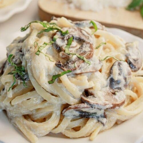 luscious creamy mushroom pasta dish in a deep bowl, garnished with fresh parsley and grated parmesan, cozy home setting