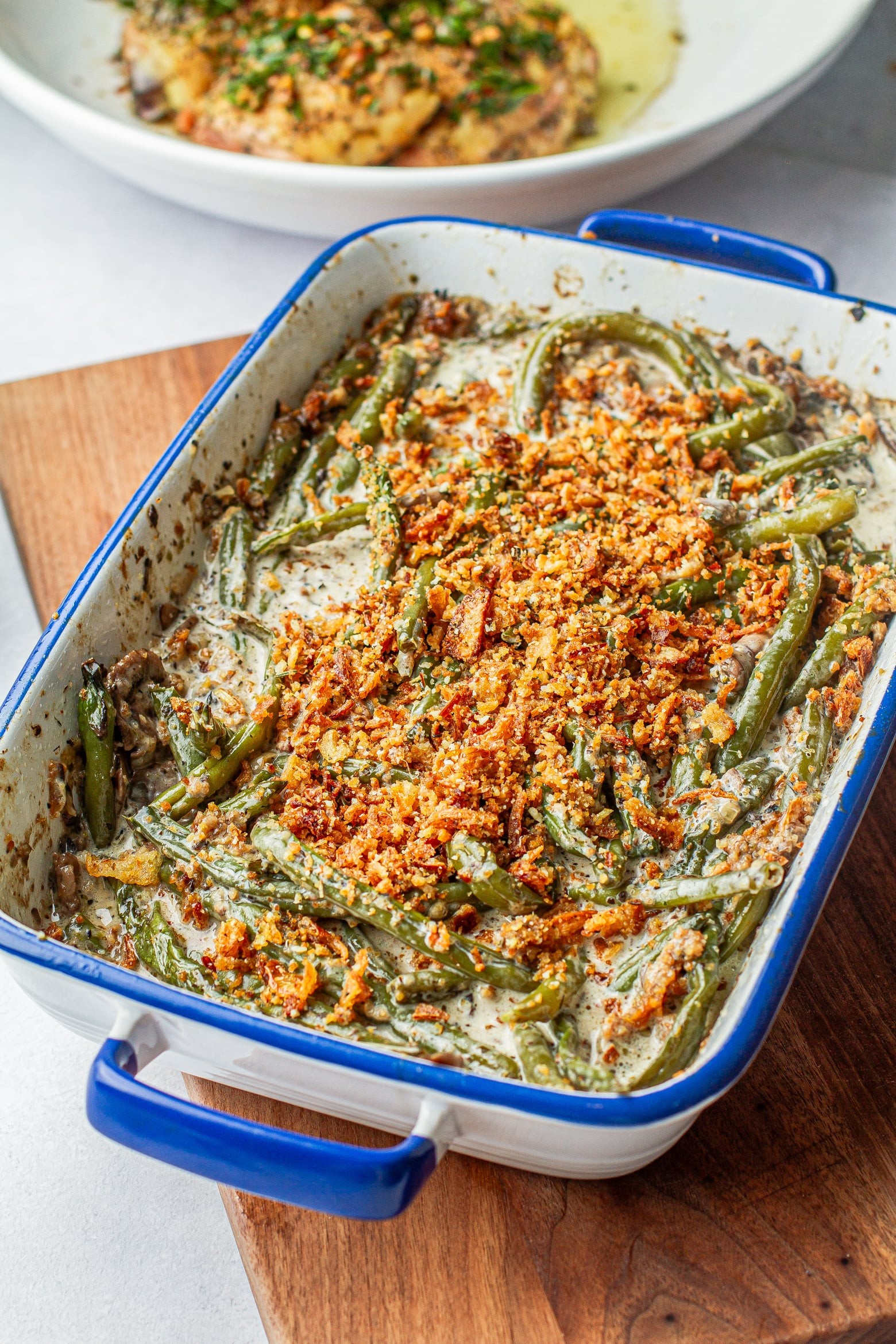 vibrant baked green bean casserole with golden fried onions and creamy garlic sauce, close up, warm lighting