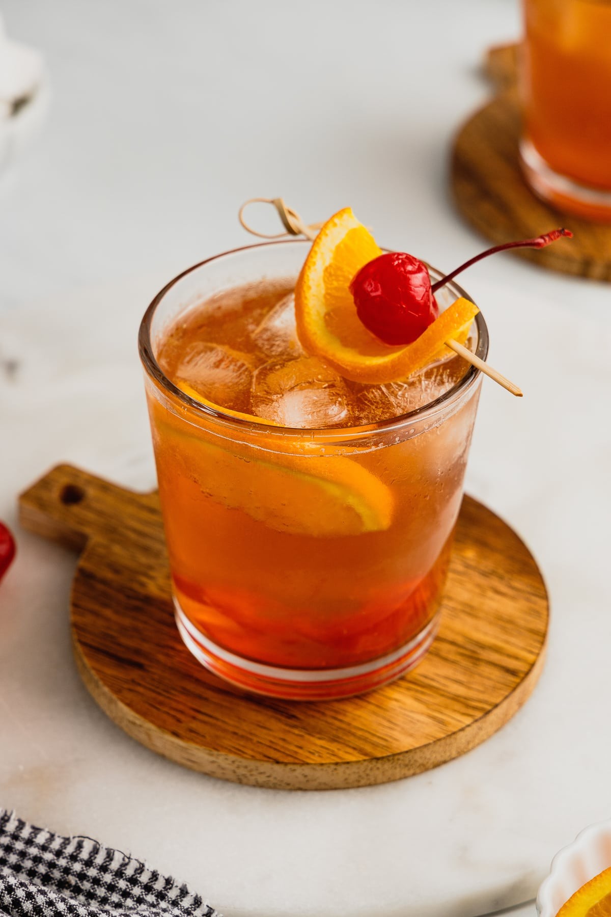 Beer-Pretzel Old Fashioned cocktail in an Old Fashioned glass with an orange peel and pretzel garnish