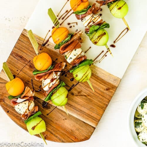 Prosciutto melon baklava skewers on a rustic wooden board